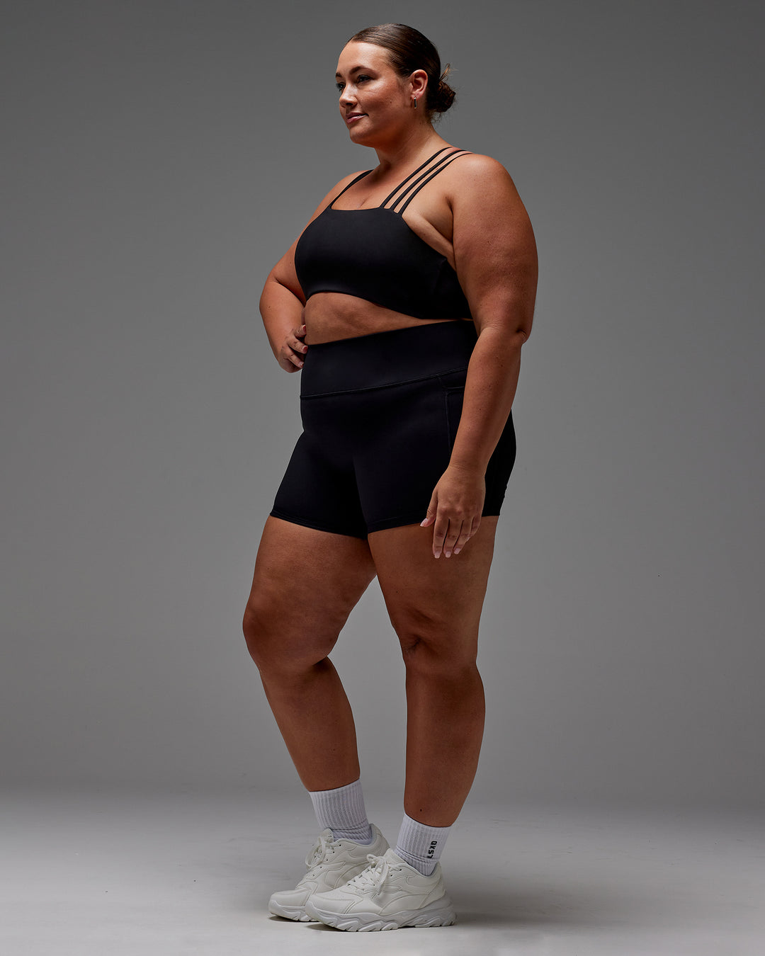 Woman wearing Fusion Ultra High-Rise 4" Short Pockets - Black | Model:Jordie | Size:2XL