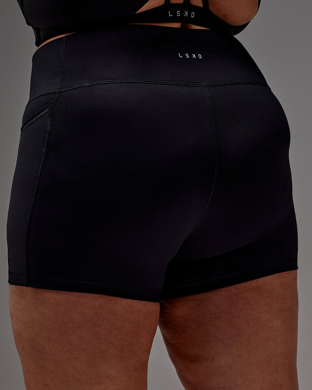 Woman wearing Fusion Ultra High-Rise 4" Short Pockets - Black | Model:Jordie | Size:2XL