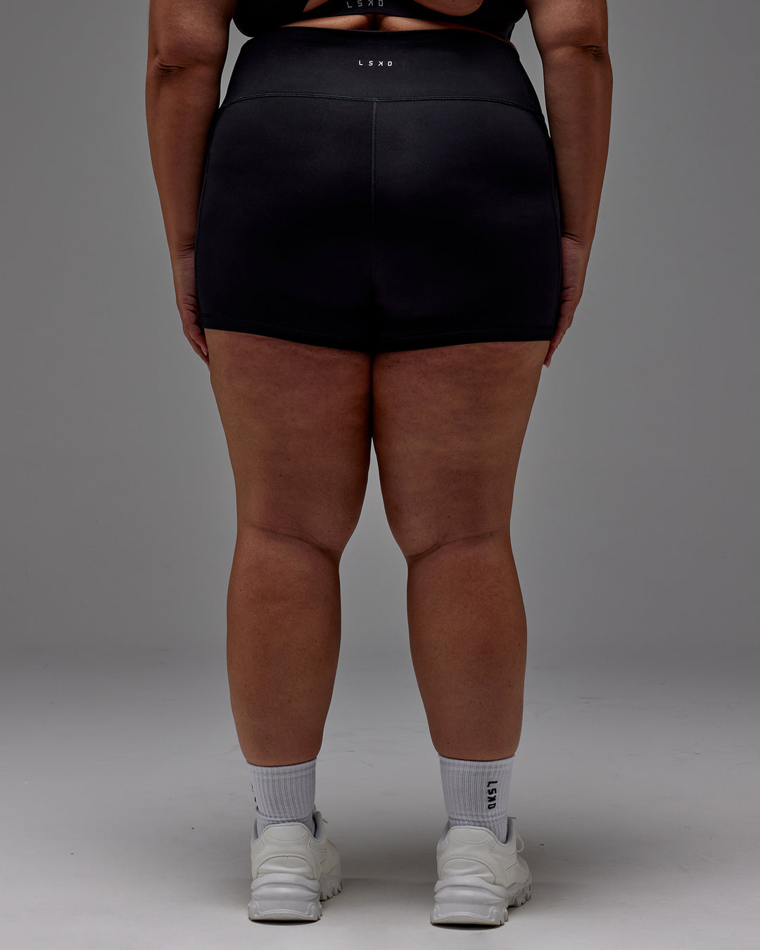 Woman wearing Fusion Ultra High-Rise 4" Short Pockets - Black | Model:Jordie | Size:2XL