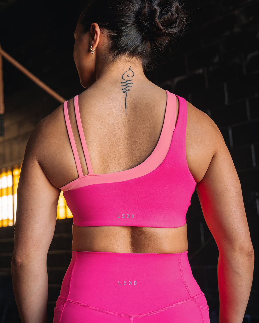 Woman wearing Thrive Asymmetric Sports Bra - Ultra Pink-Candy Pink | Model:Teraipine | Size:M