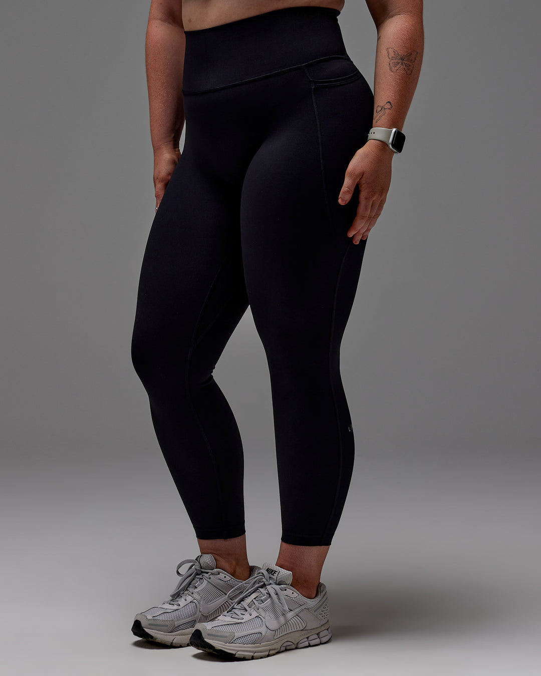 Woman wearing Fusion Ultra High-Rise 7/8 Legging Pockets - Black | Model:Caity | Size:M