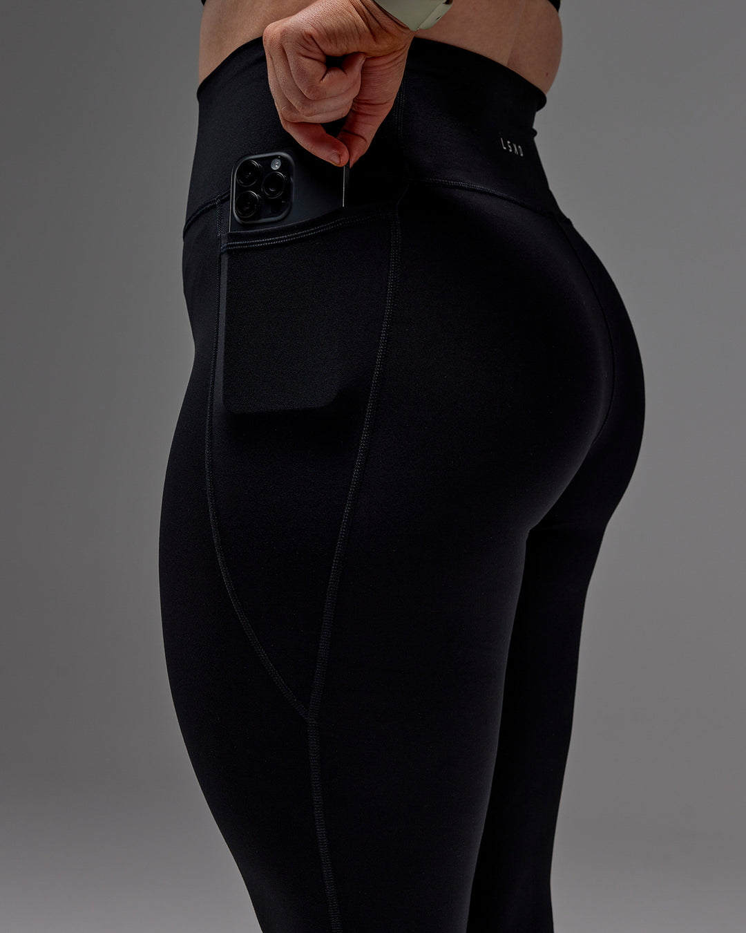 Woman wearing Fusion Ultra High-Rise 7/8 Legging Pockets - Black | Model:Caity | Size:M