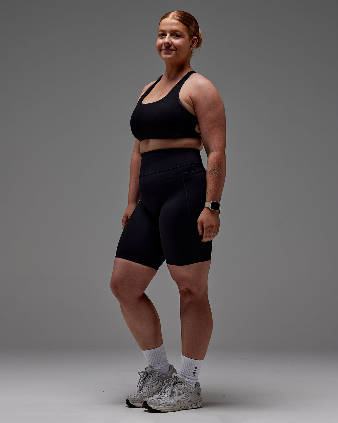 Woman wearing Fusion Ultra High-Rise 9" Short Pockets - Black | Model:Caity | Size:M