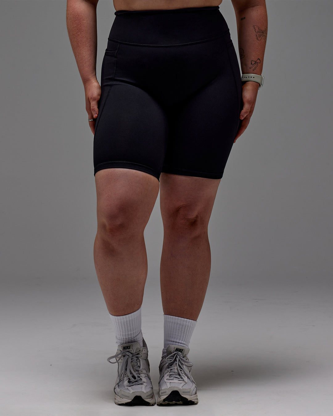 Woman wearing Fusion Ultra High-Rise 9" Short Pockets - Black | Model:Caity | Size:M