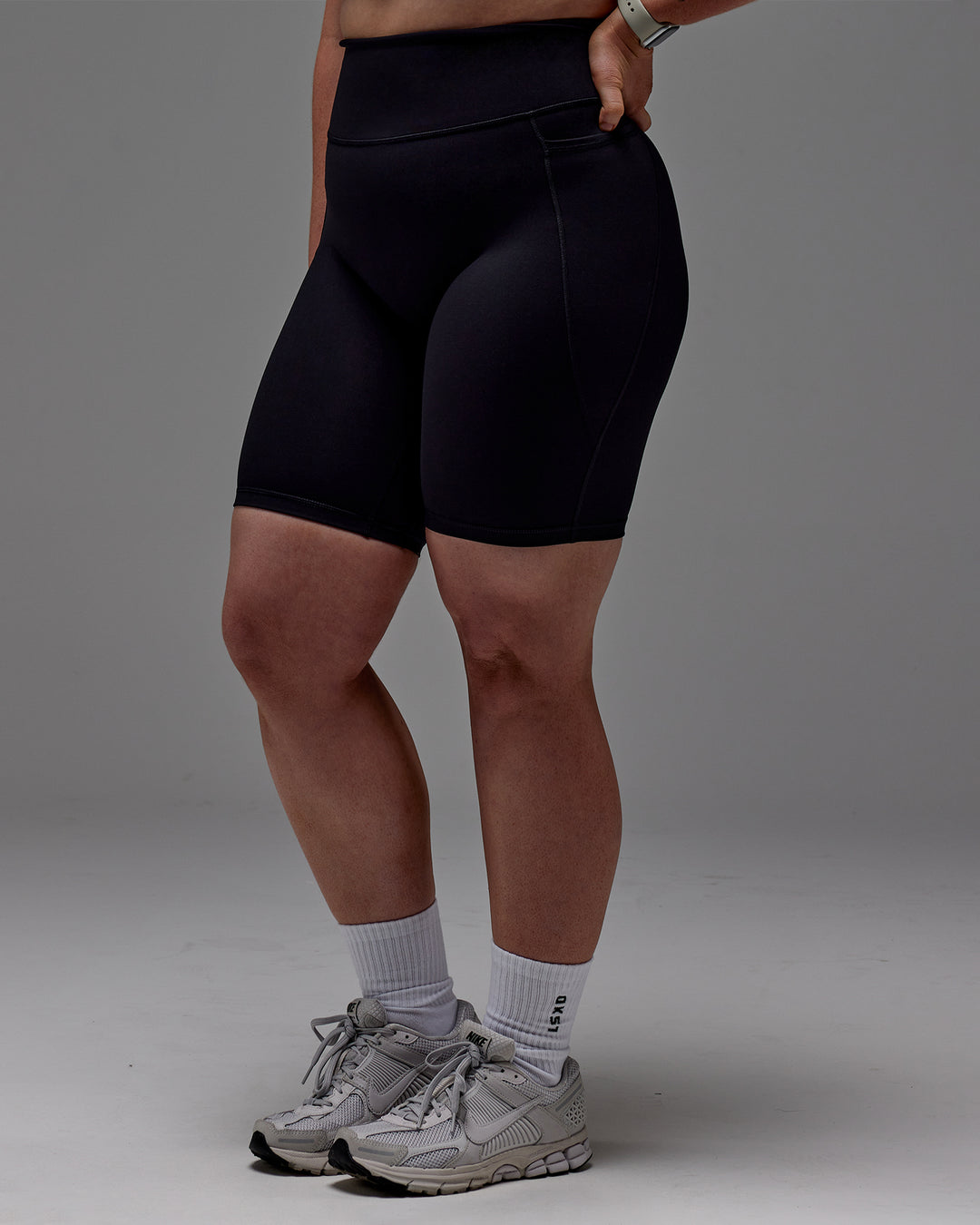 Woman wearing Fusion Ultra High-Rise 9" Short Pockets - Black | Model:Caity | Size:M