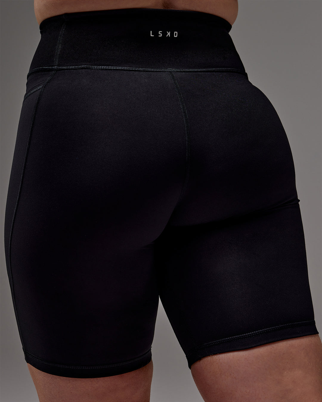 Woman wearing Fusion Ultra High-Rise 9" Short Pockets - Black | Model:Caity | Size:M