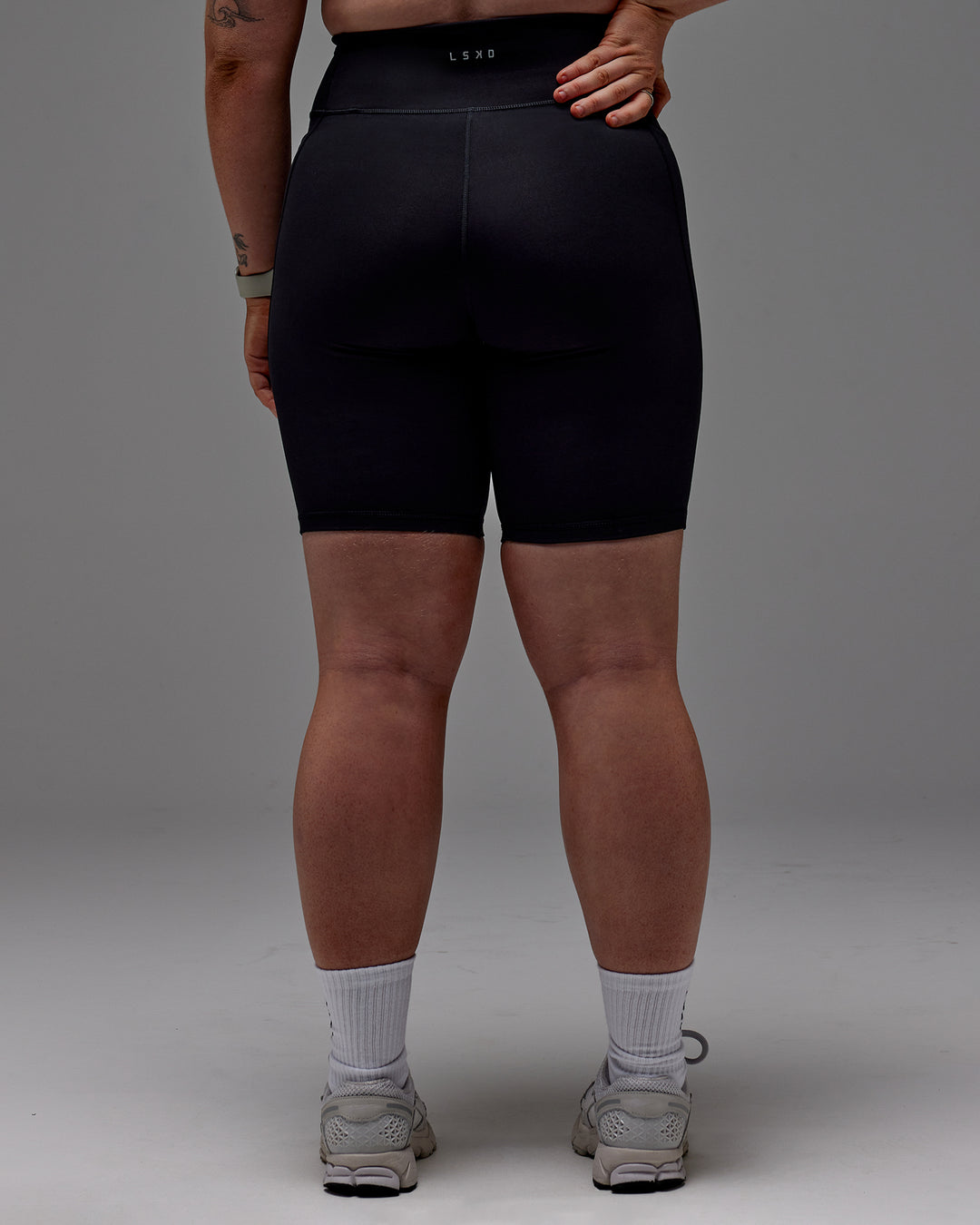 Woman wearing Fusion Ultra High-Rise 9" Short Pockets - Black | Model:Caity | Size:M