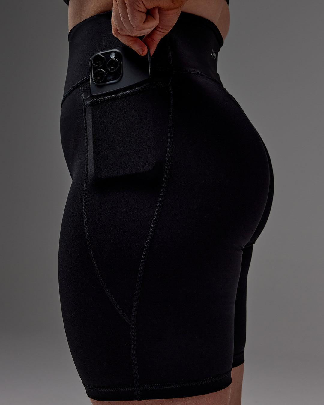 Woman wearing Fusion Ultra High-Rise 9" Short Pockets - Black | Model:Caity | Size:M