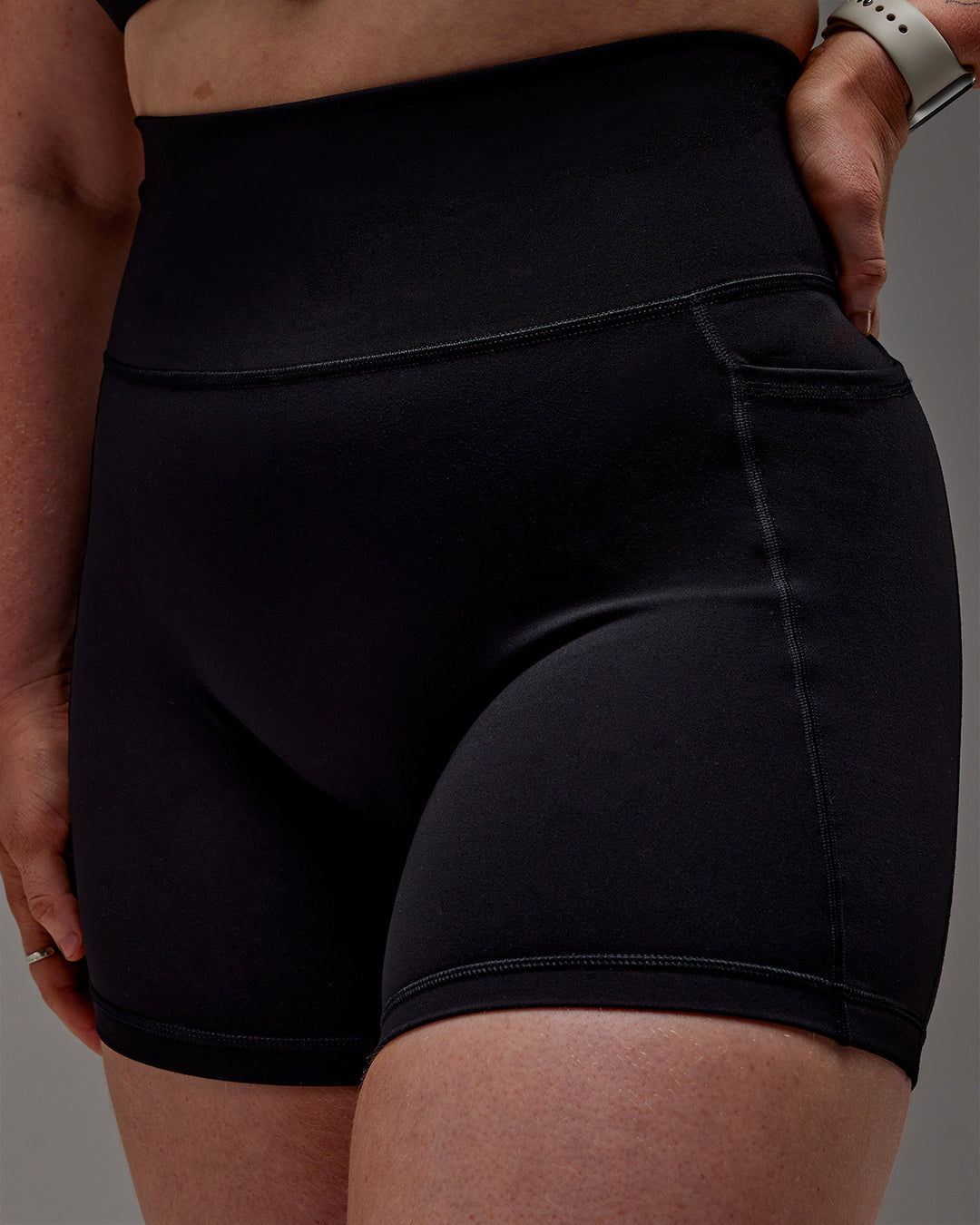 Woman wearing Fusion Ultra High-Rise 6" Short Pockets - Black | Model:Caity | Size:M