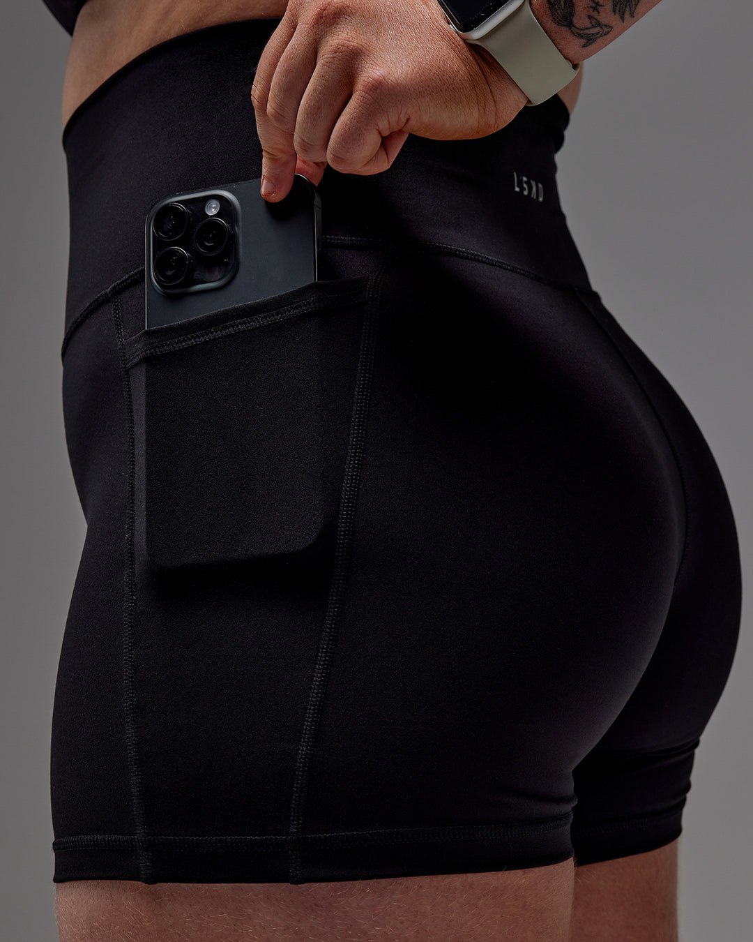 Woman wearing Fusion Ultra High-Rise 4" Short Pockets - Black | Model:Caity | Size:M