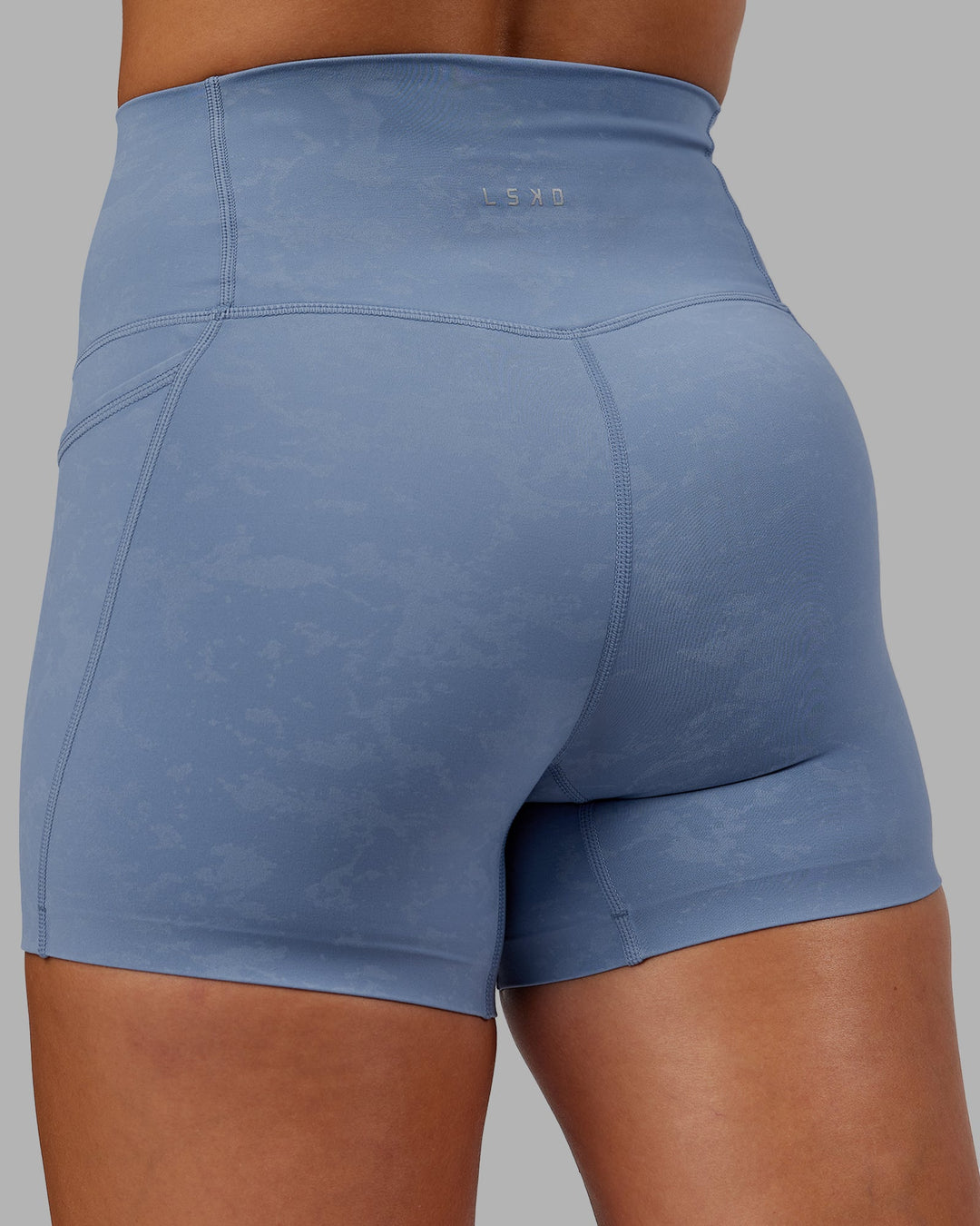 Woman wearing Abs Elixir Ultra High-Rise 4" Short Pockets - Infinity Mirage