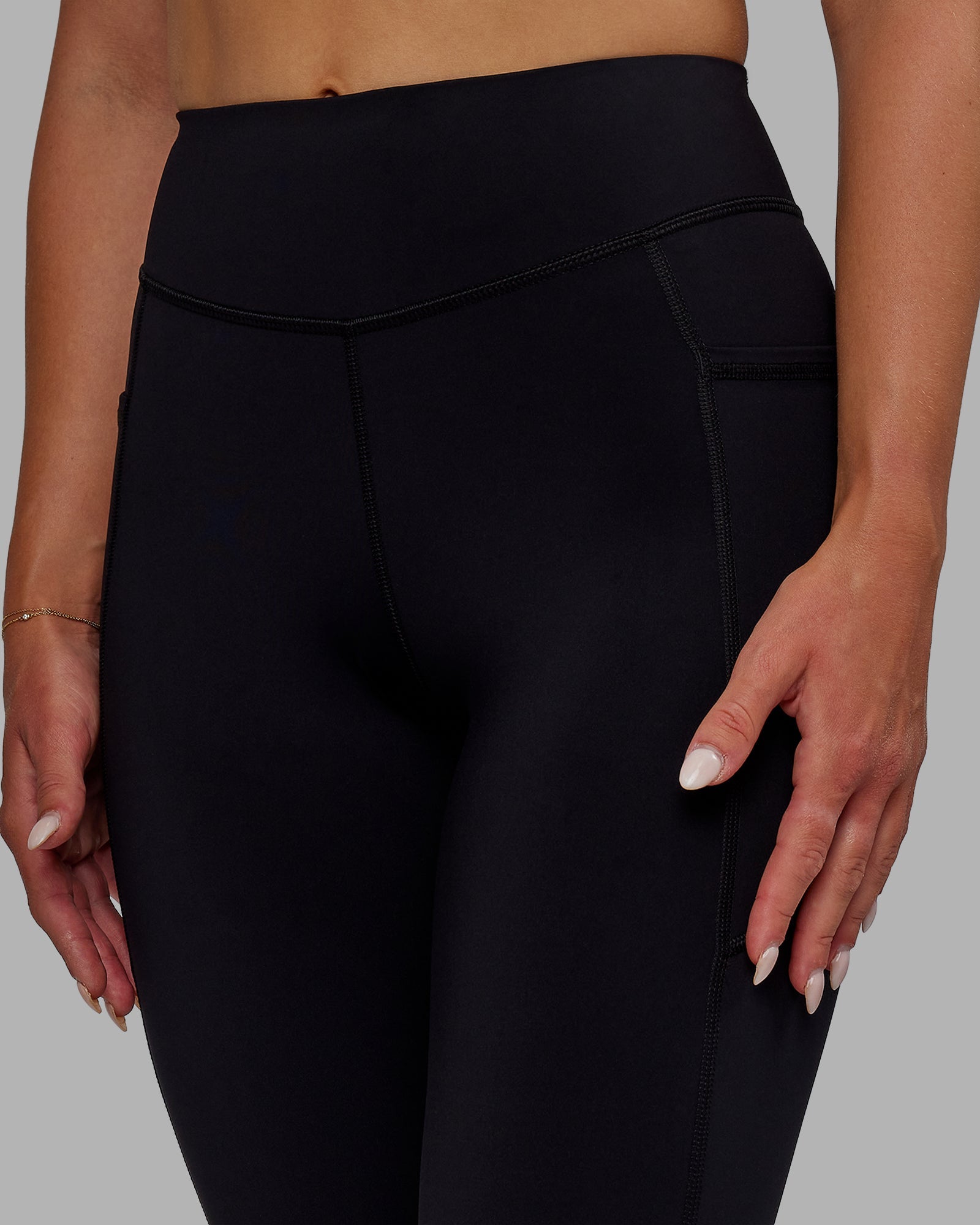 Woman wearing Elite High-Rise 7/8 Legging Pockets - Black
