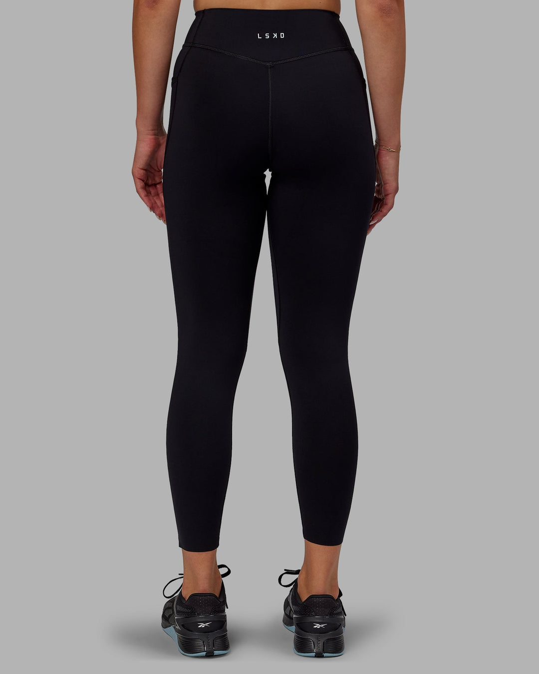 Woman wearing Elite High-Rise 7/8 Legging Pockets - Black