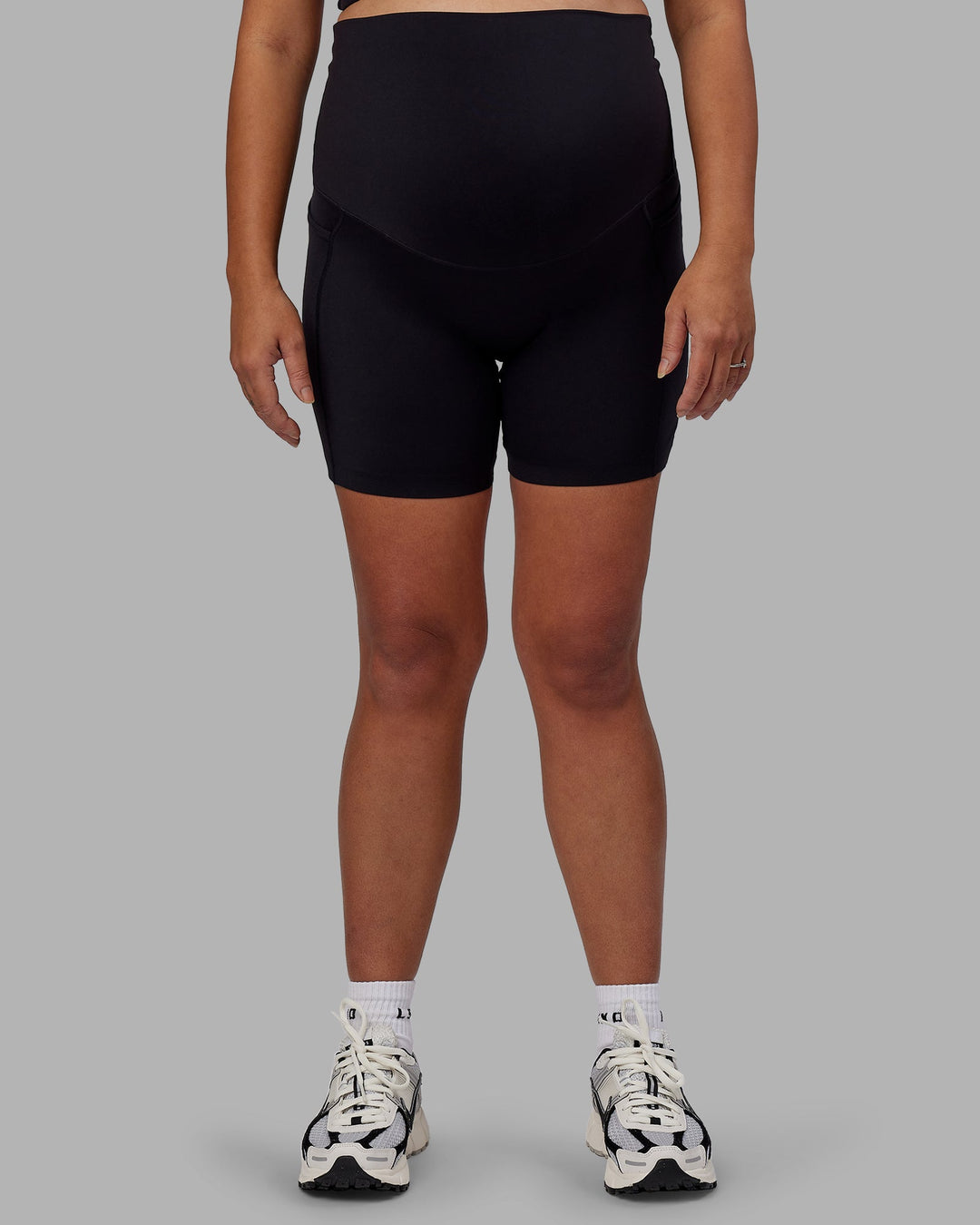 Woman wearing Elixir Ultra High-Rise Maternity 6" Short Pockets - Black | Model:Jojo | Size:M