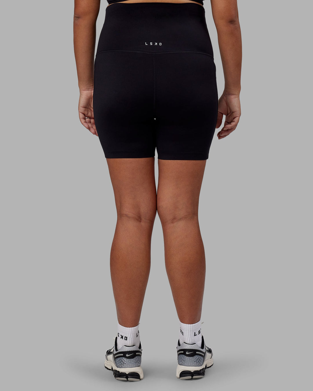 Woman wearing Elixir Ultra High-Rise Maternity 6" Short Pockets - Black | Model:Jojo | Size:M
