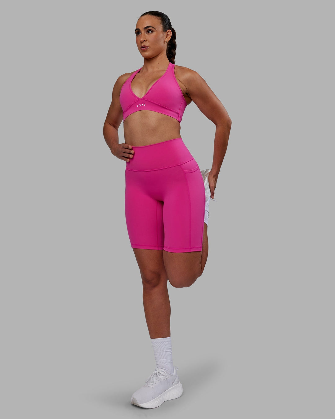 Woman wearing Fusion Ultra High-Rise 9" Short Pockets - Fuchsia Pink | Model:Sophie | Size:S