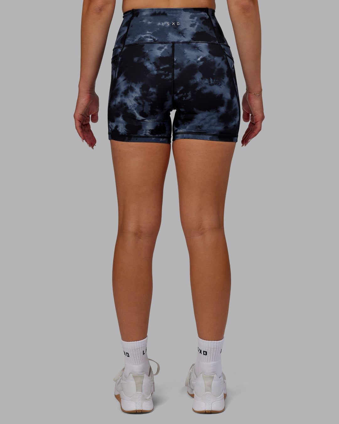 Woman wearing Fusion Ultra High-Rise 4" Short Pockets - Tie Dye-Midnight | Model:Halle | Size:S