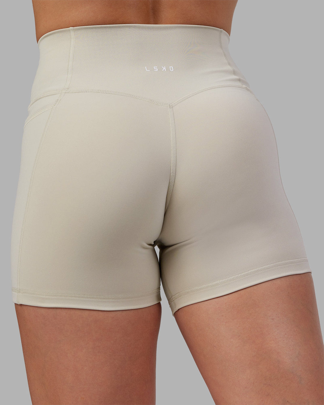 Woman wearing Abs Fusion High-Rise 4" Short Pockets - Shale Beige | Model:Abbey | Size:S