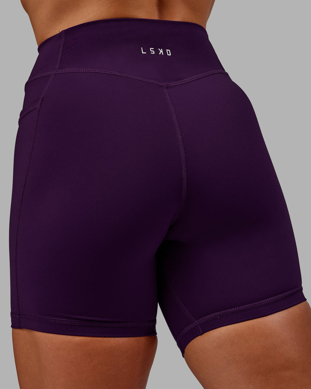 Woman wearing Elite High-Rise 6" Short Pockets in Deep Purple | Size:S