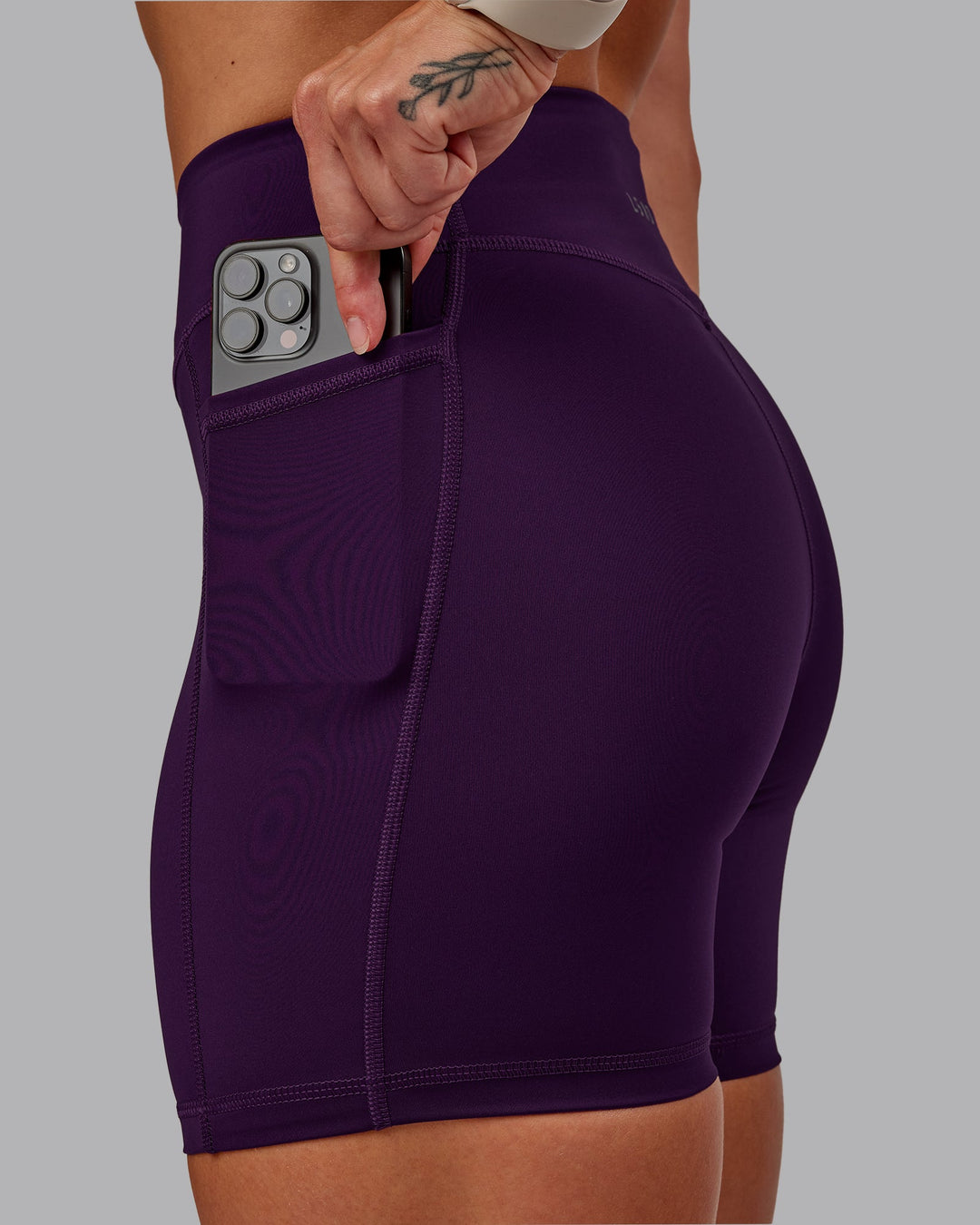 Woman wearing Elite High-Rise 6" Short Pockets in Deep Purple | Size:S