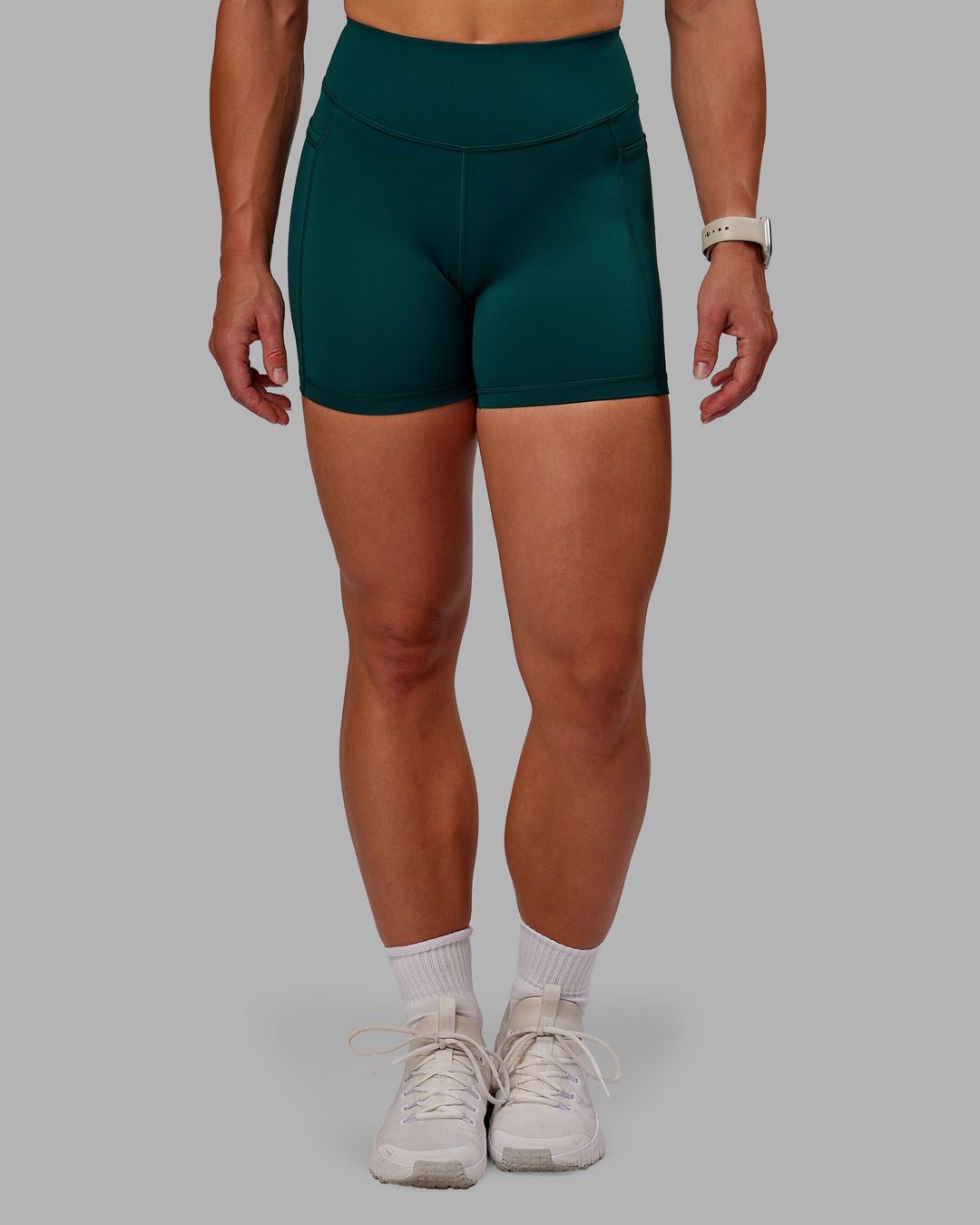 Woman wearing Elite High-Rise 4" Short Pockets - Dark Moss| Size:S