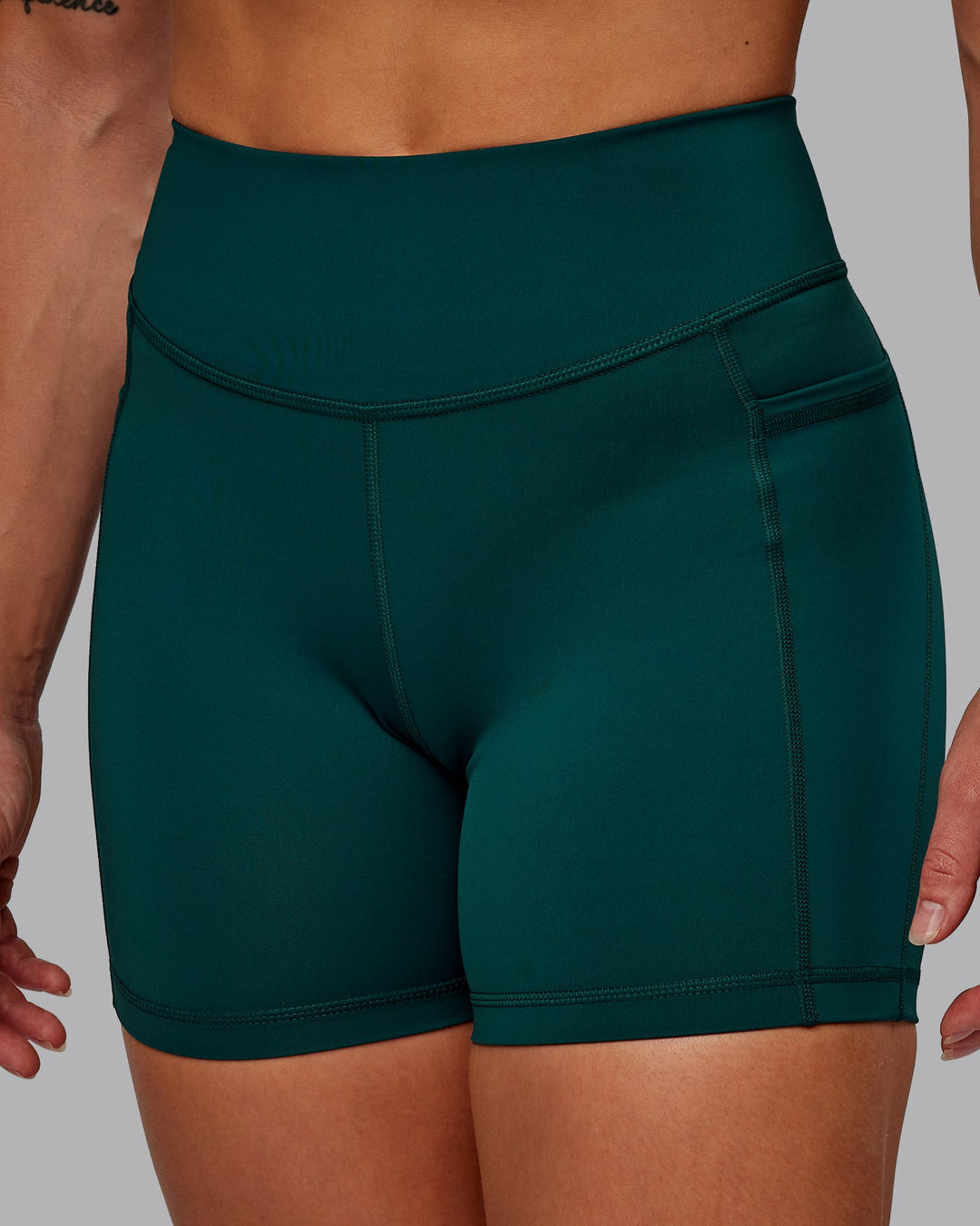 Woman wearing Elite High-Rise 4" Short Pockets - Dark Moss| Size:S