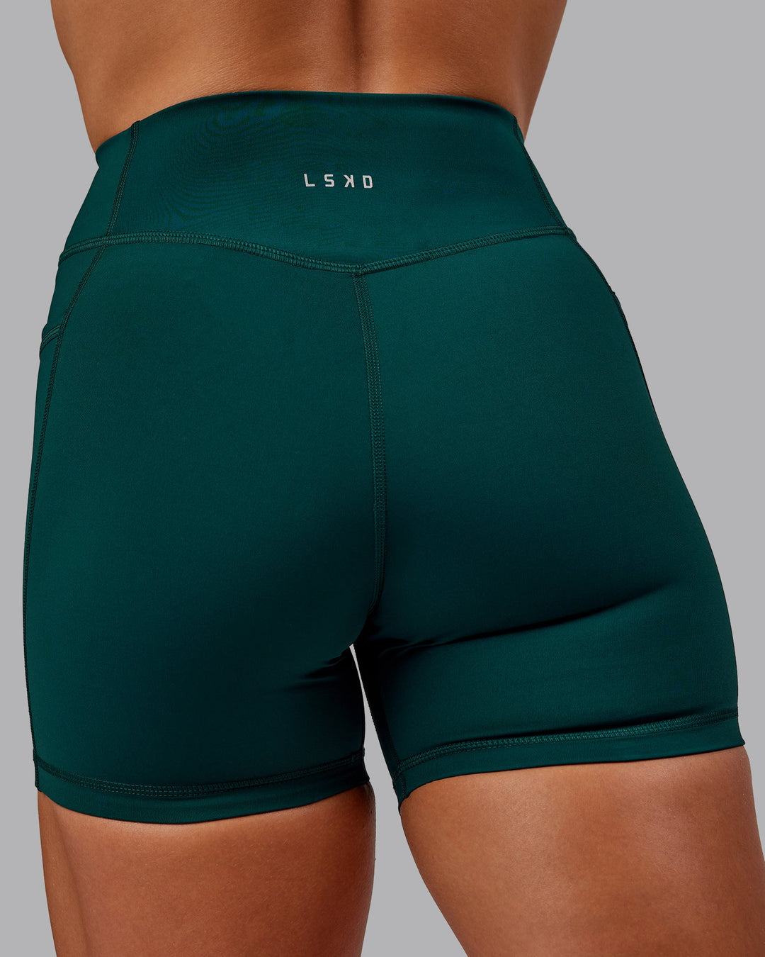 Woman wearing Elite High-Rise 4" Short Pockets - Dark Moss| Size:S