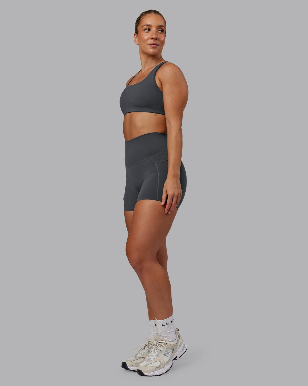 Woman wearing Elixir Ultra High-Rise 4" Short Pockets in Dark Storm | Size:S