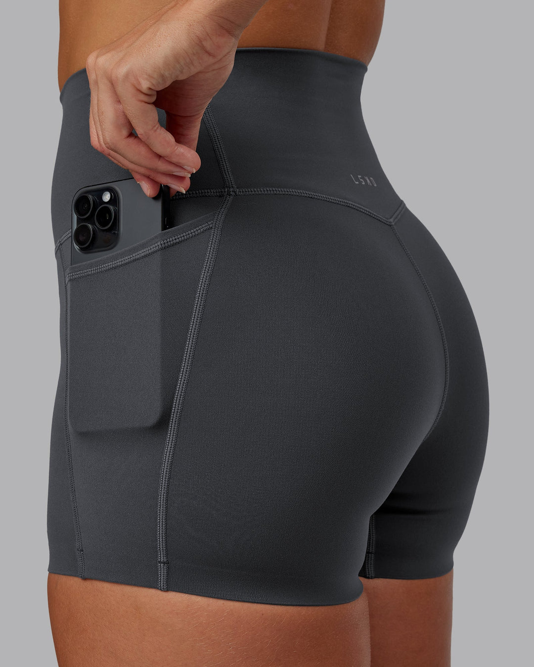 Woman wearing Elixir Ultra High-Rise 4" Short Pockets in Dark Storm | Size:S
