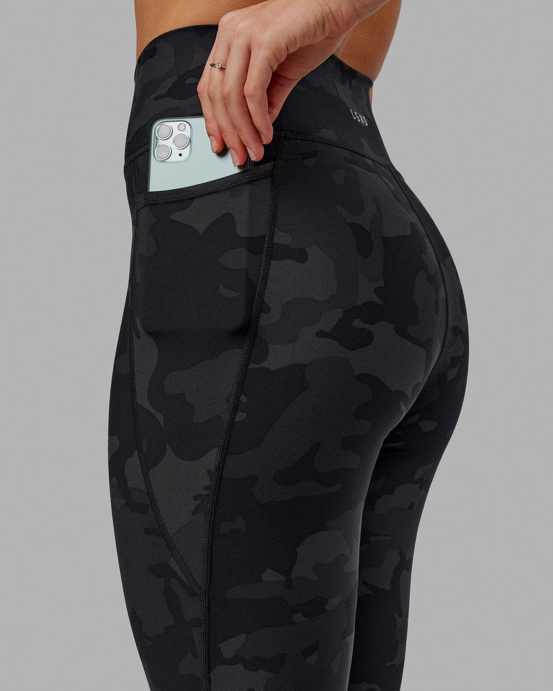 Woman wearing Fusion Ultra High-Rise 7/8 Legging Pockets - Black-Camo | Model:Katie | Size:S