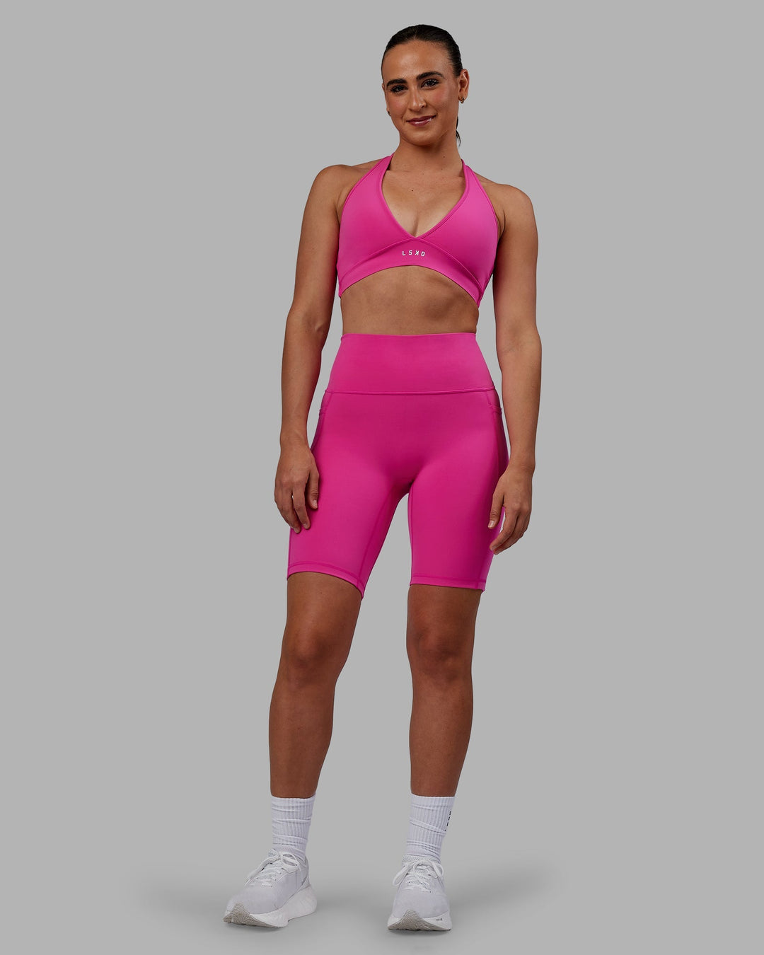 Woman wearing Fusion Ultra High-Rise 9" Short Pockets - Fuchsia Pink | Model:Sophie | Size:S