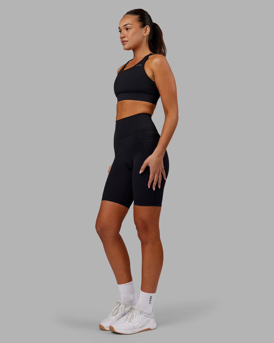 Woman wearing Fusion Ultra High-Rise 9" Short Pockets - Black | Model:Kirstyn | Size:S