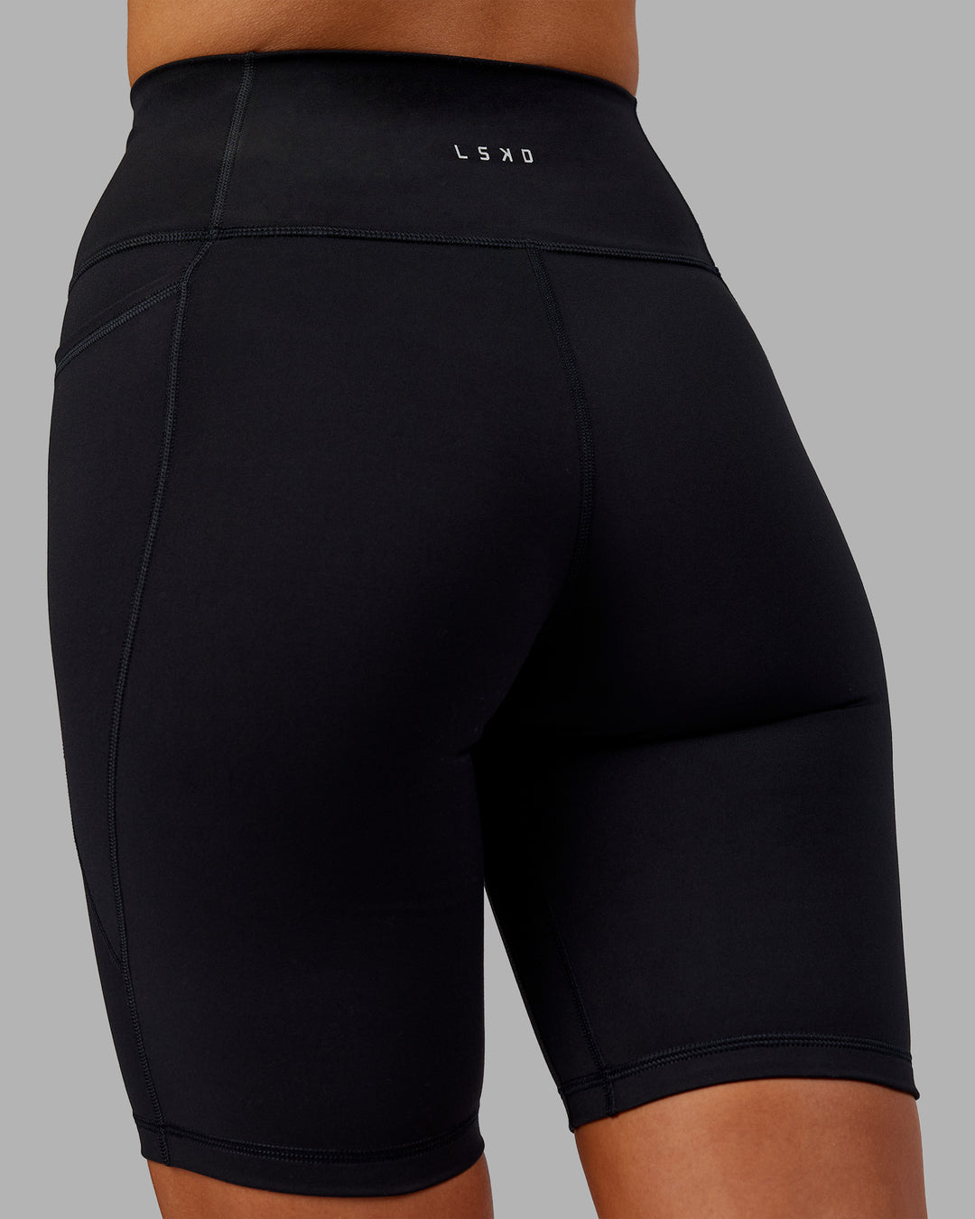 Woman wearing Fusion Ultra High-Rise 9" Short Pockets - Black | Model:Kirstyn | Size:S