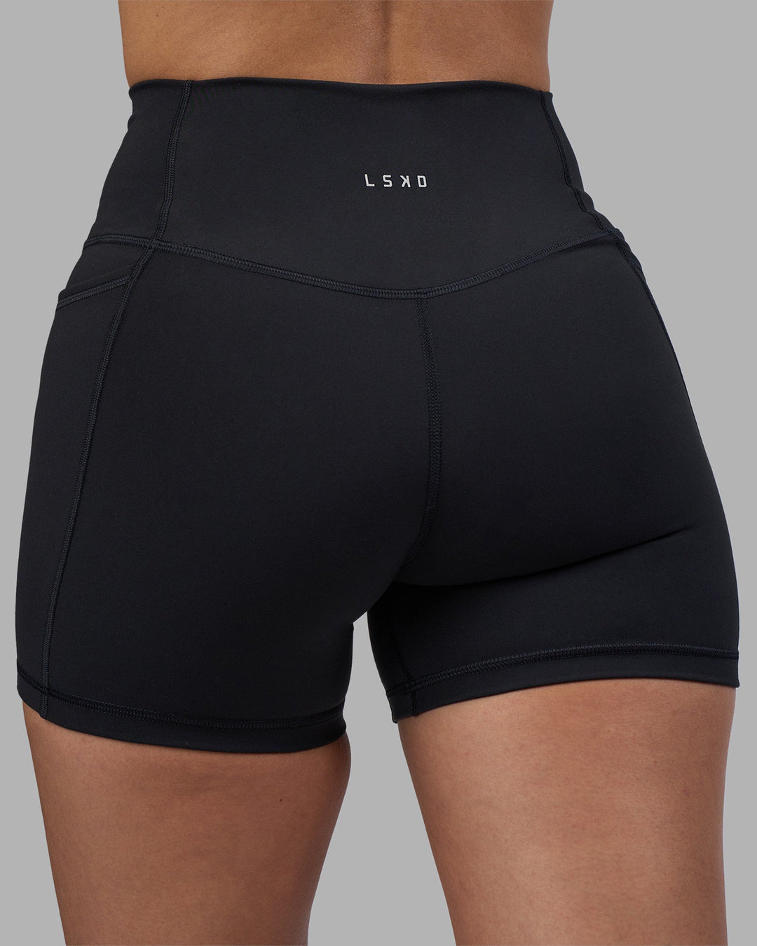Woman wearing Fusion High-Rise 4" Short Pockets - Black | Model:Rhiley | Size:S