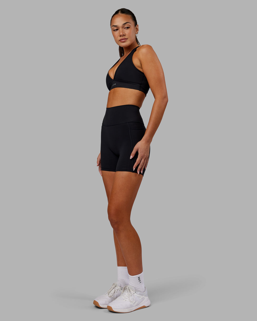 Woman wearing Fusion Ultra High-Rise 6" Short Pockets - Black | Model:Kirstyn | Size:S