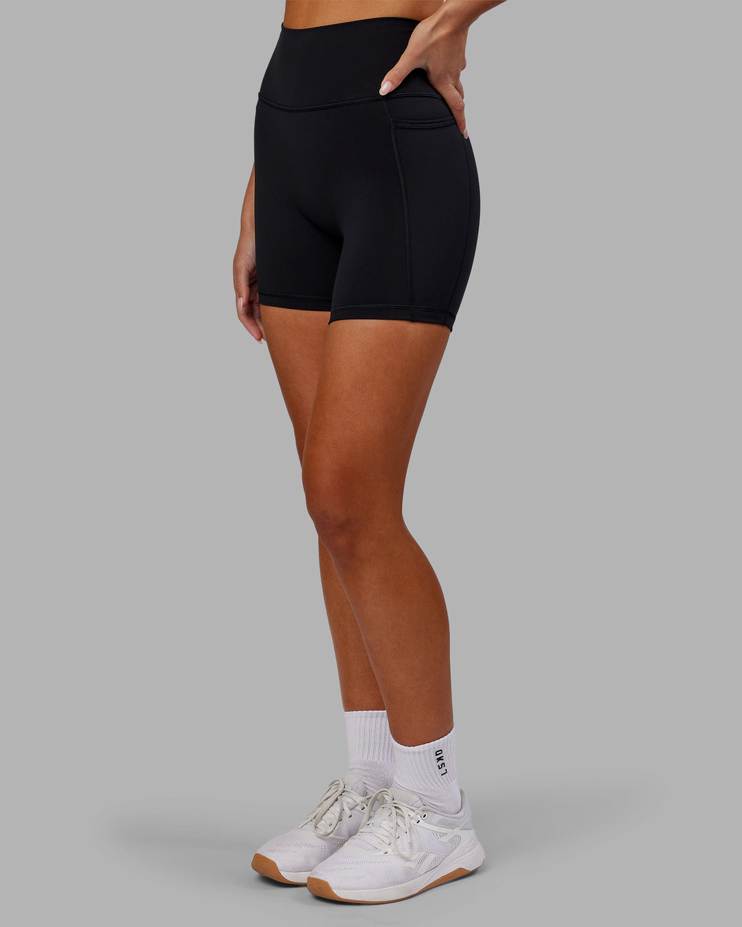 Woman wearing Fusion Ultra High-Rise 6" Short Pockets - Black | Model:Kirstyn | Size:S