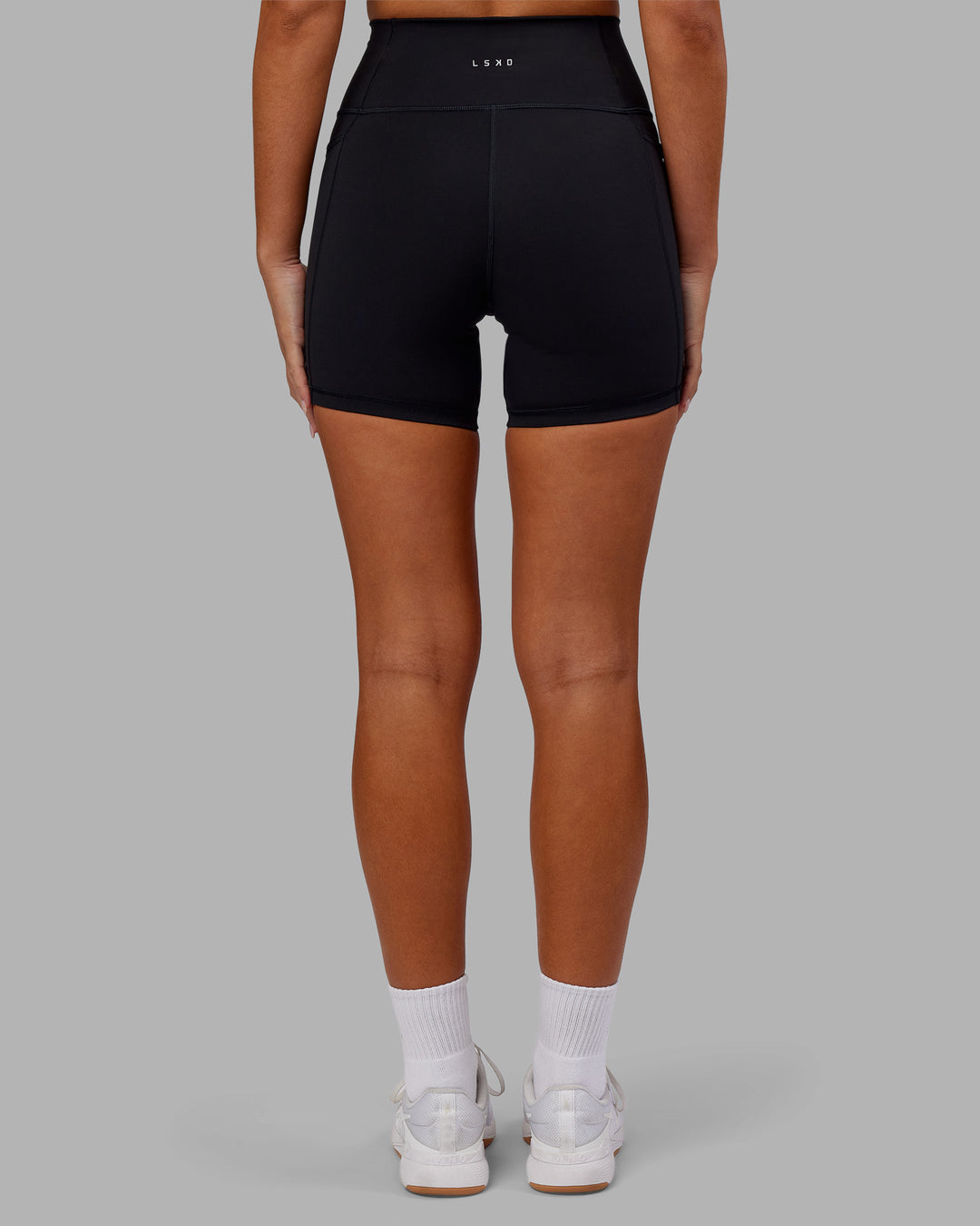 Woman wearing Fusion Ultra High-Rise 6" Short Pockets - Black | Model:Kirstyn | Size:S
