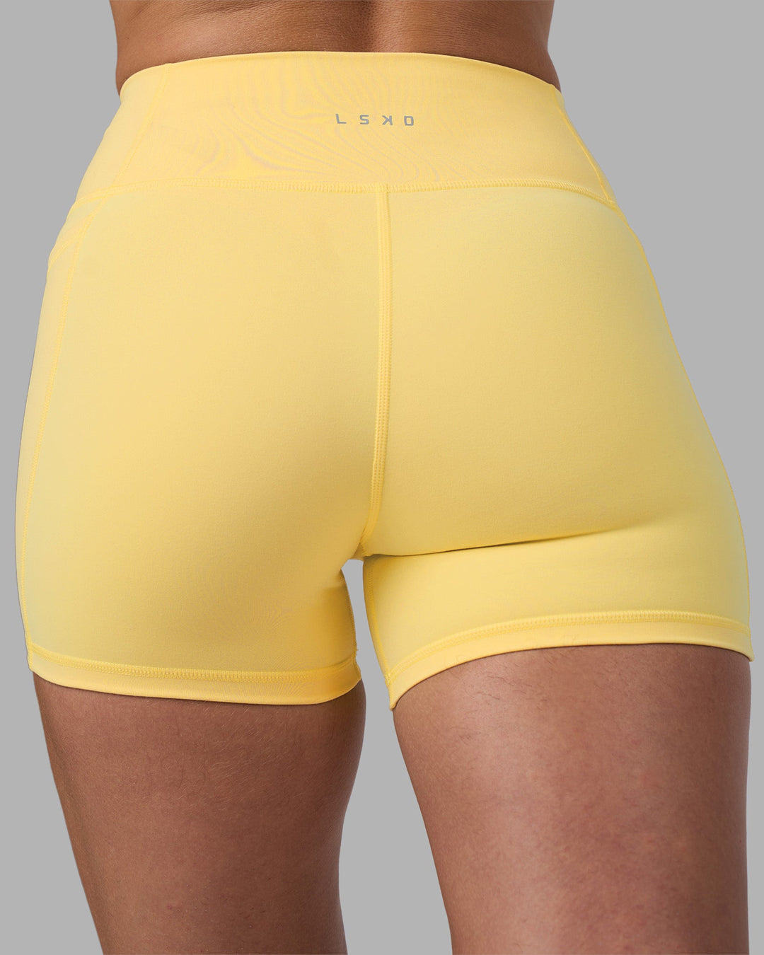 Woman wearing Fusion Ultra High-Rise 4" Short Pockets - Lemon | Model:Sophie | Size:S