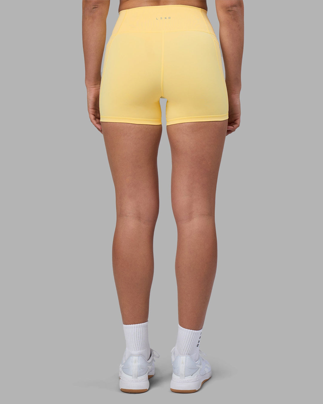 Woman wearing Fusion Ultra High-Rise 4" Short Pockets - Lemon | Model:Sophie | Size:S