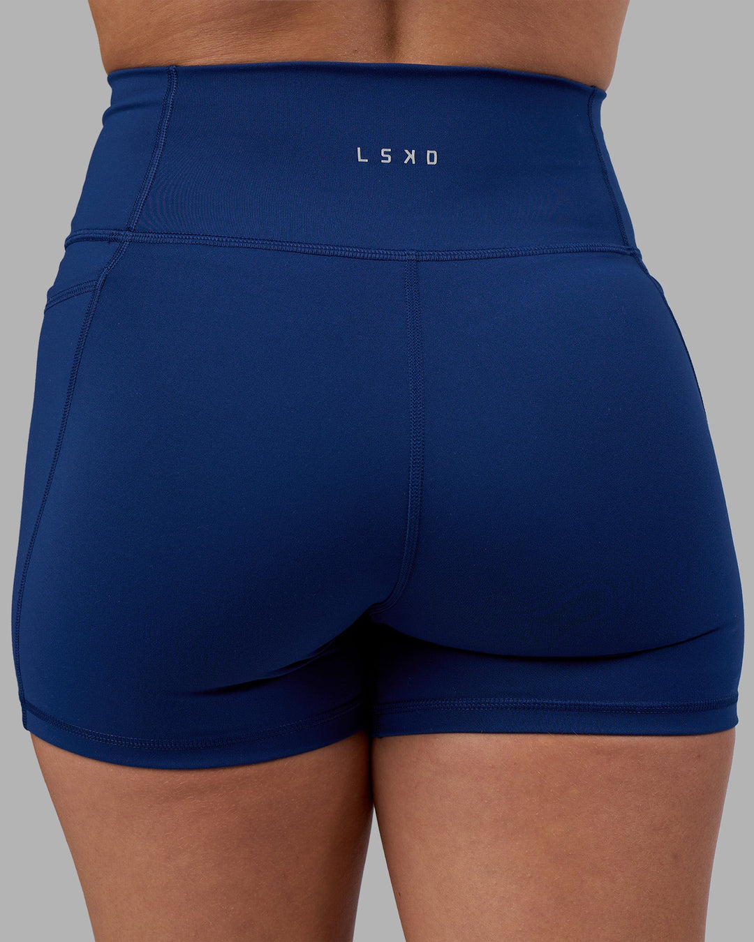 Woman wearing Fusion Ultra High-Rise 4" Short Pockets - Midnight Blue | Model:Charlize | Size:S