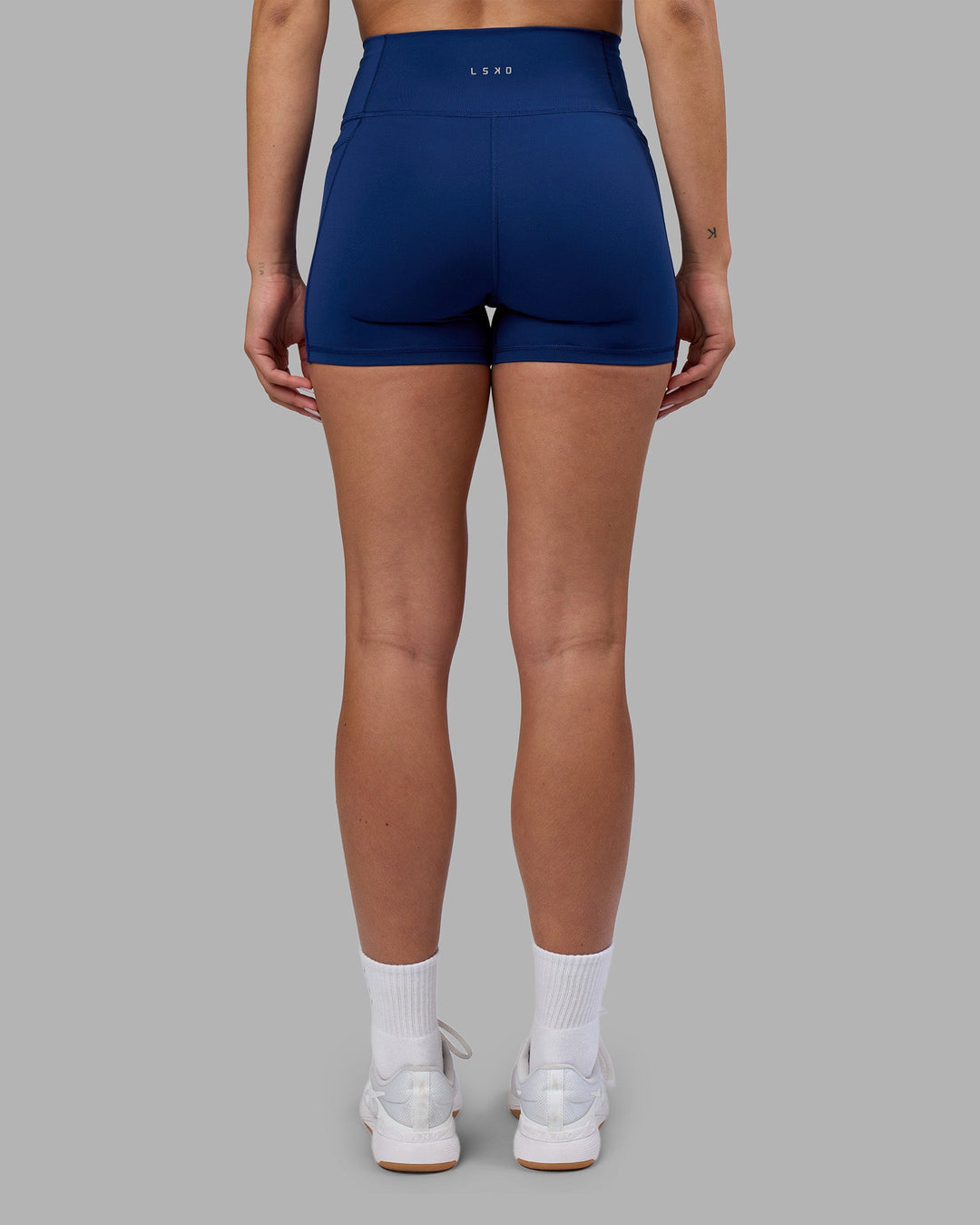 Woman wearing Fusion Ultra High-Rise 4" Short Pockets - Midnight Blue | Model:Charlize | Size:S