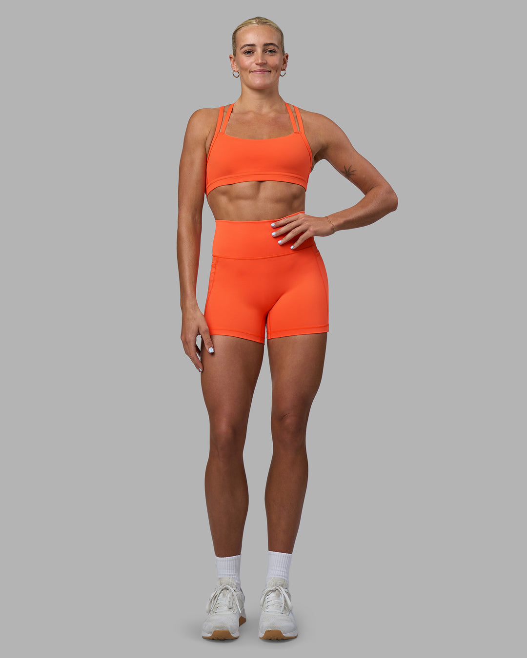 Woman wearing Fusion Ultra High-Rise 4" Short Pockets - Ultra Orange | Model:Katie | Size:S