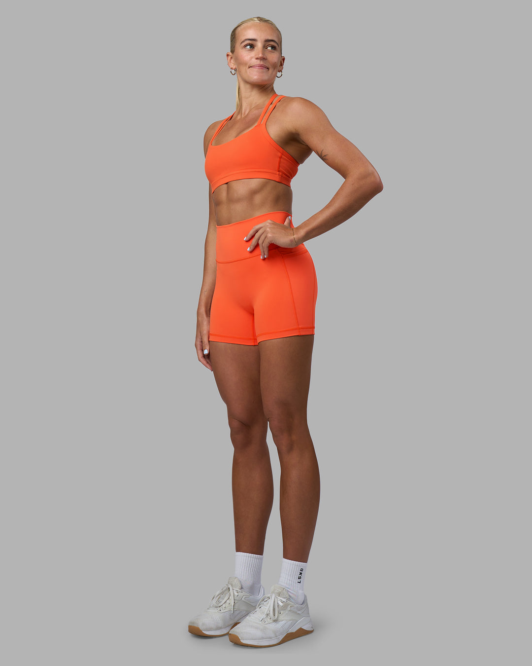 Woman wearing Fusion Ultra High-Rise 4" Short Pockets - Ultra Orange | Model:Katie | Size:S