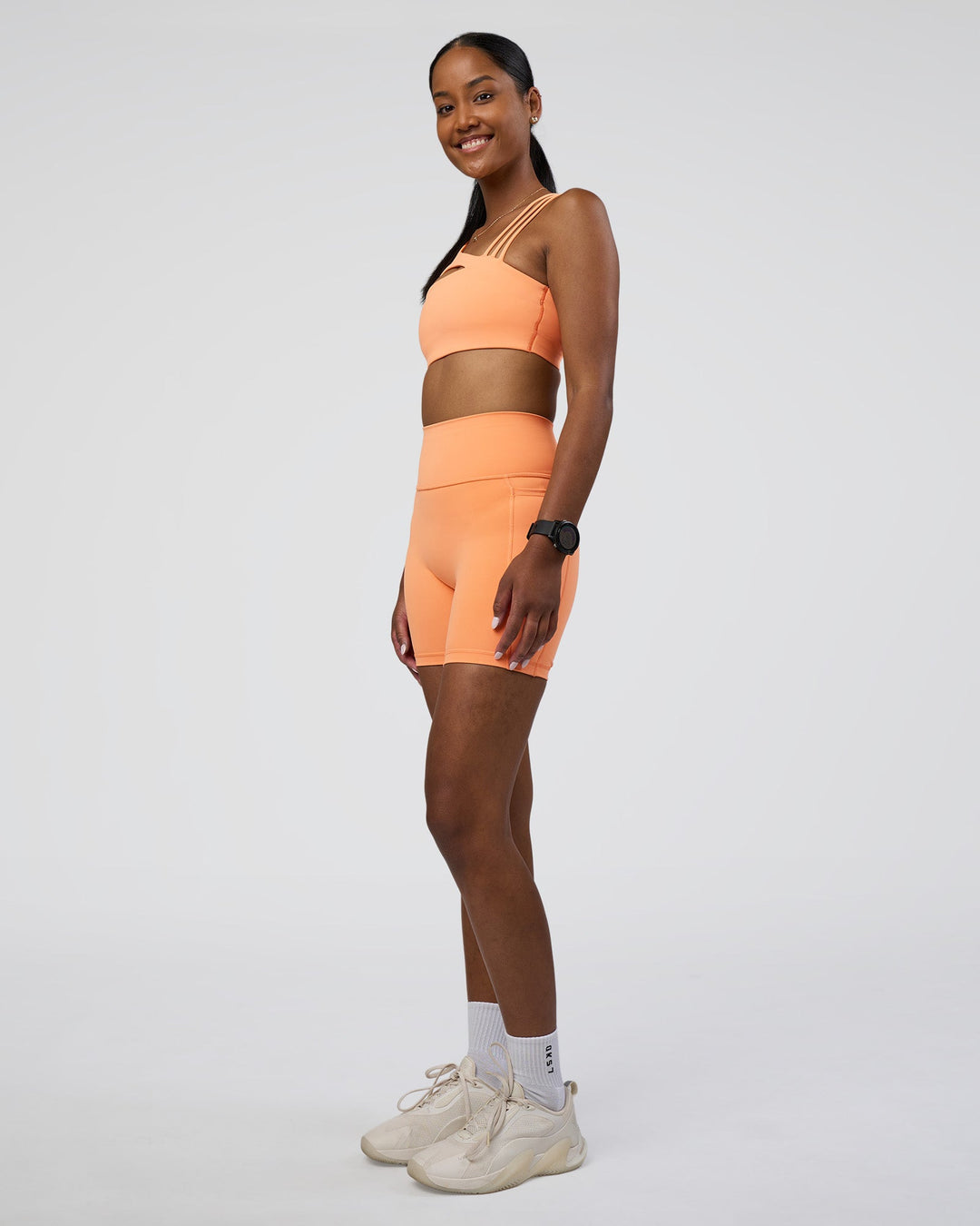 Woman wearing Fusion Ultra High-Rise 6" Short Pockets - Cantaloupe | Model:Rica | Size:S