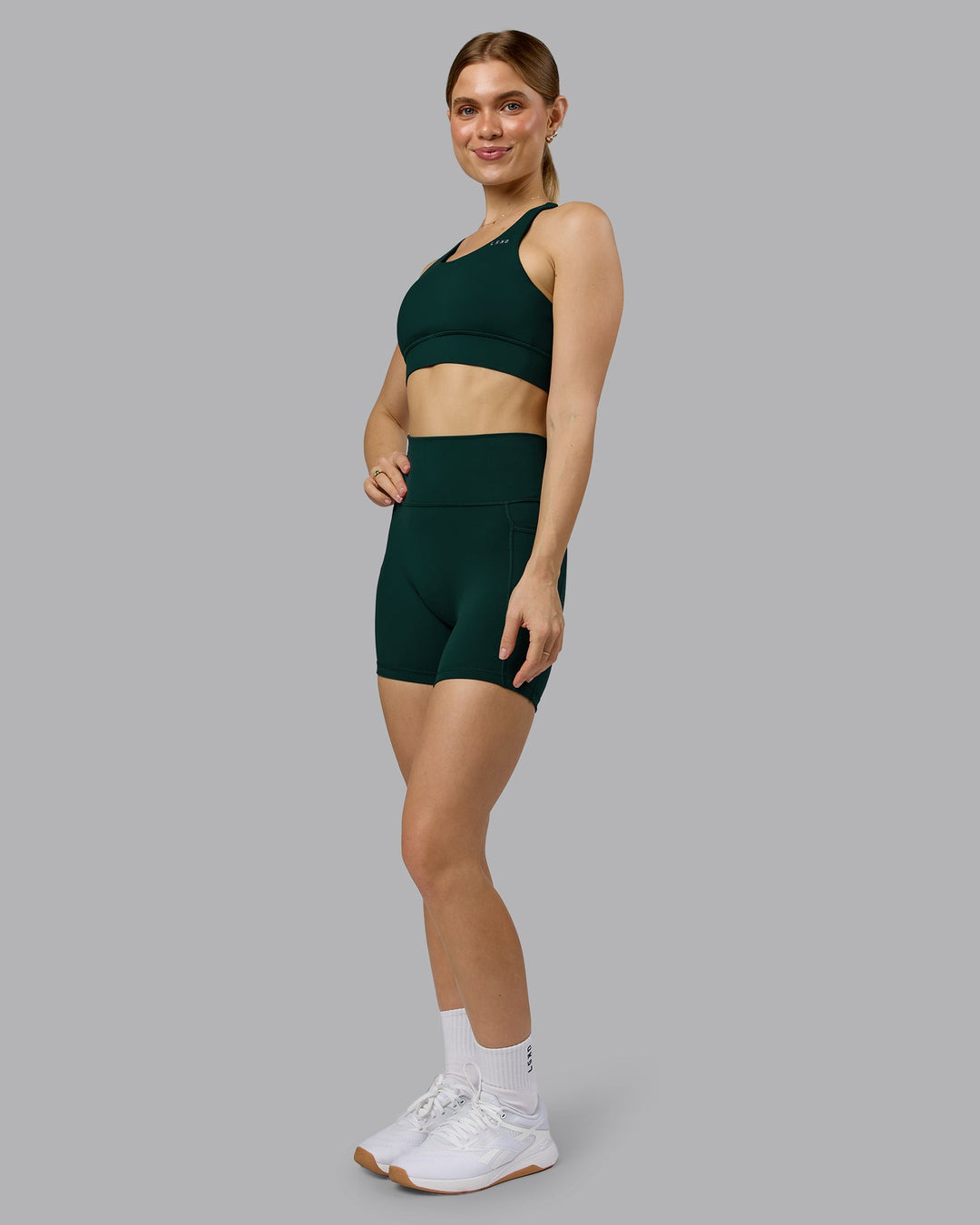 Woman wearing Fusion Ultra High-Rise 6" Short Pockets - Dark Moss | Model:Emilie | Size:S