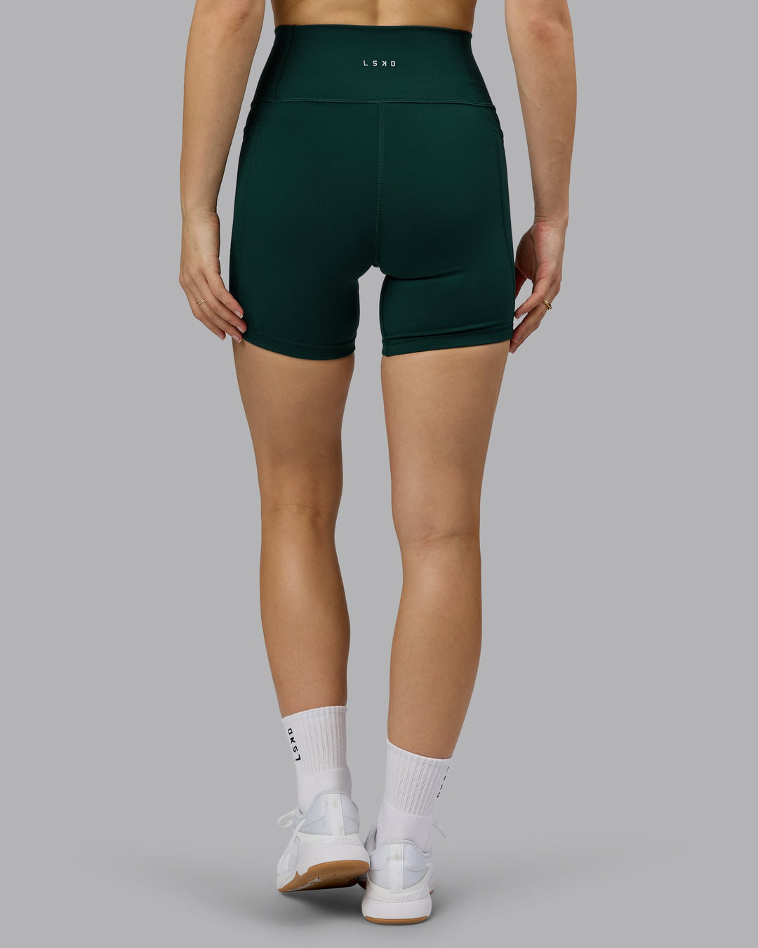Woman wearing Fusion Ultra High-Rise 6" Short Pockets - Dark Moss | Model:Emilie | Size:S