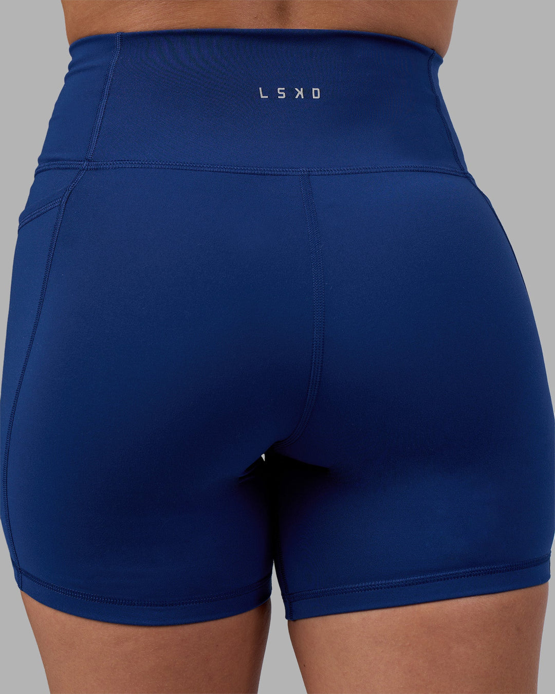 Woman wearing Fusion Ultra High-Rise 6" Short Pockets - Midnight Blue | Model:Charlize | Size:S