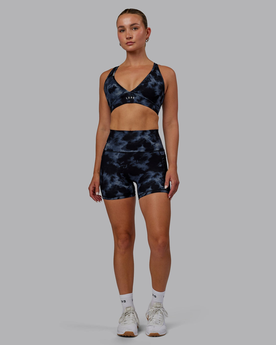 Woman wearing Fusion Ultra High-Rise 4" Short Pockets - Tie Dye-Midnight | Model:Halle | Size:S