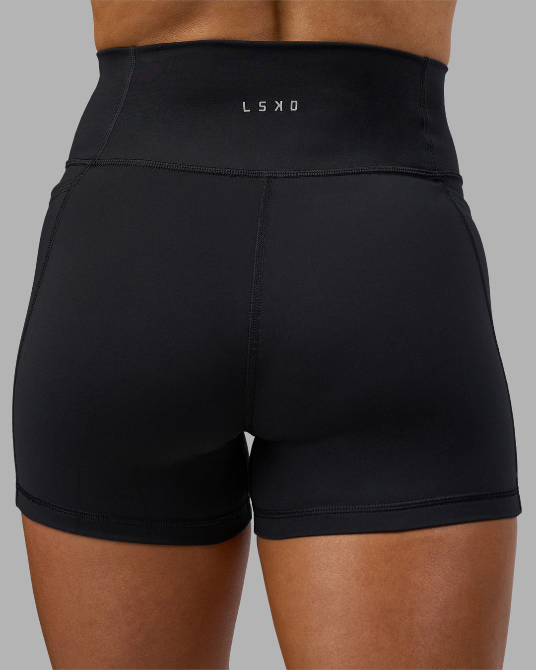 Woman wearing Fusion Ultra High-Rise 4" Short Pockets - Black | Model:Georgia | Size:S