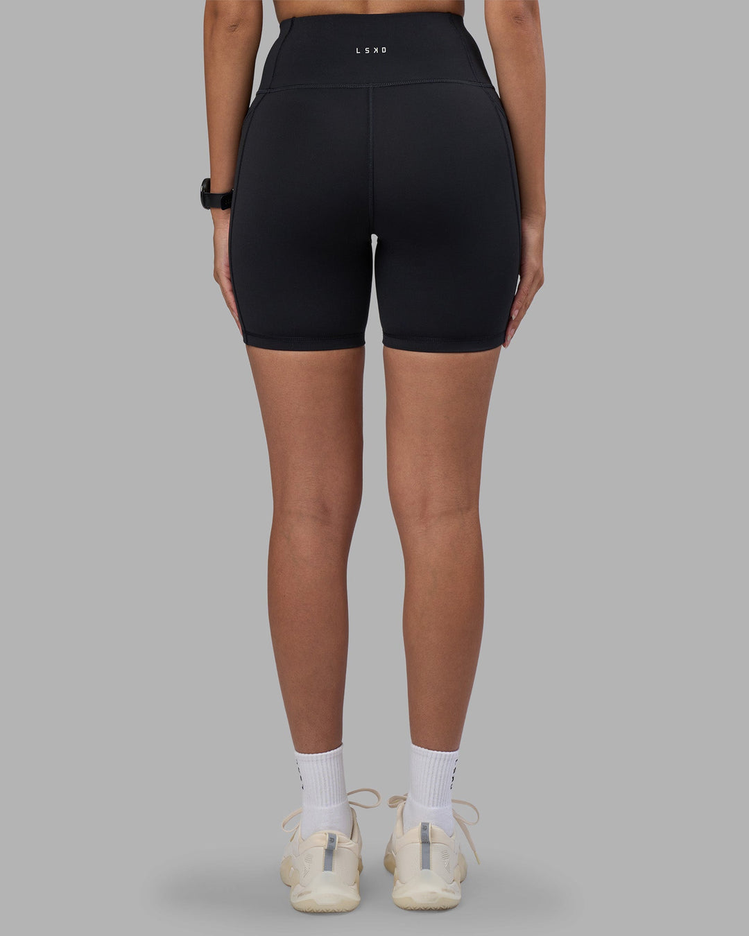 Woman wearing Rep Ultra High-Rise 6" Short Pockets - Black-Power Cobalt | Model:Rhiley | Size:S